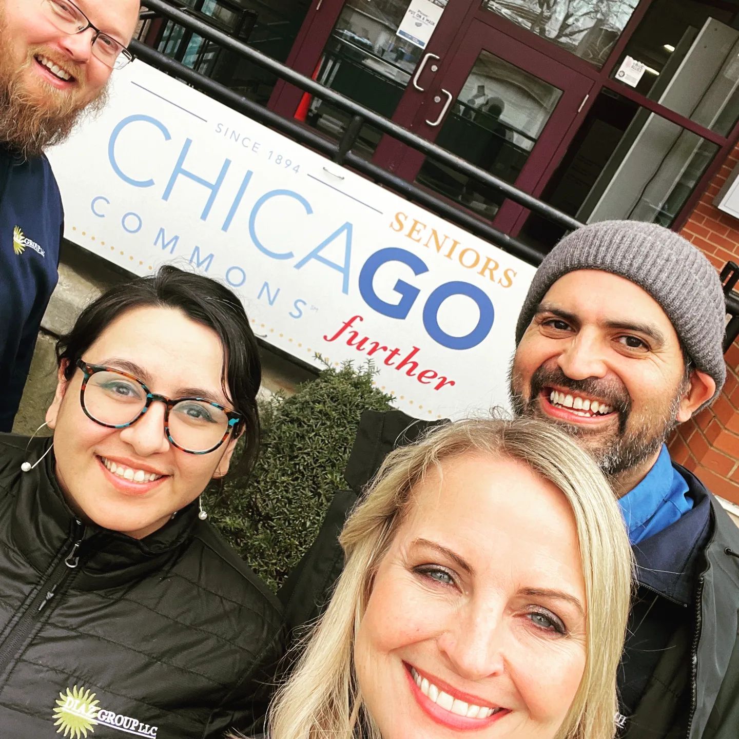 A group of four employees from Diaz Group LLC take a selfie in front of the Adult Day Services (ADS) center at Chicago Commons, located in the Bronzeville neighborhood in Chicago, Illinois.